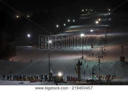 5 January 2017. Zuberec Ski Park. Slovakia. Western Tatras. Europe. Ski with the lift at night lit by lanterns. Night skiing. Adults and children skiing after work. Concept of healthy active lifestyle.