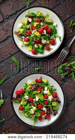 Fresh Tasty Raspberry salad with avocado, green vegetables, nuts, feta cheese, olive oil and herbs. healthy food