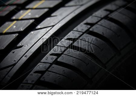 Studio shot of a set of summer car tires on black background close up. Contrasty lighting