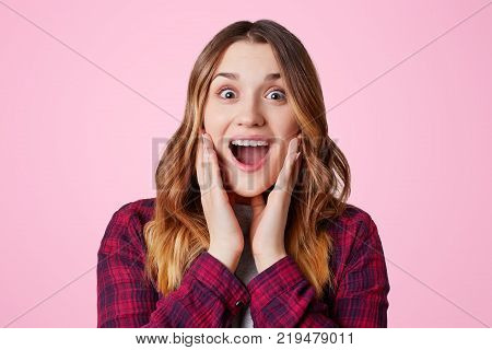 Headshot Of Unhappy Sorrorful Female Curves Lips, Looks Desperately At Camera, Being Upset To Hear B