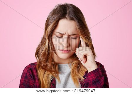 Headshot Of Unhappy Sorrorful Female Curves Lips, Looks Desperately At Camera, Being Upset To Hear B
