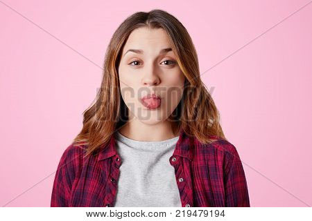 Headshot Of Unhappy Sorrorful Female Curves Lips, Looks Desperately At Camera, Being Upset To Hear B