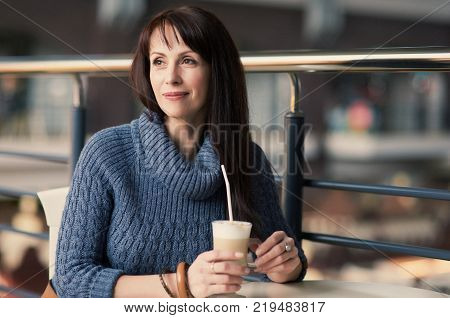 happy lonely woman drinking coffee in cafe