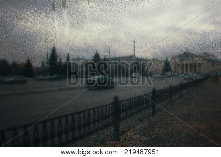 Autumn street on a rainy day view through wet glass