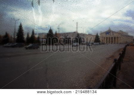Autumn street on a rainy day view through wet glass