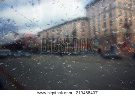 Autumn street on a rainy day view through wet glass