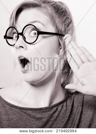 Rumors and gossips concept. Newsmonger girl making listening gesture. Shocked surprised gossiping woman. Gossip and chatter.