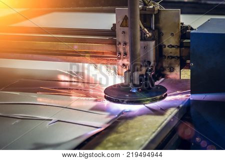 Plasma cut machine cutting steel sheet with sparks. Lasercutting  of industrial iron works, toned