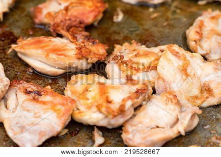 Fried steaks on metal skillet. Roasted juicy meat. Chicken bbq at street food fair
