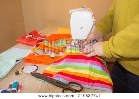 Woman hand on sewing machine. Dressmaker work on the sewing machine. Hobby sewing fabric as a small business concept. Female fashion designer working