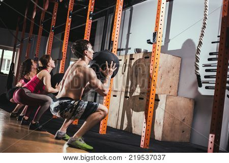 fitness, sport and exercising concept - group of people with medicine balls training in gym
