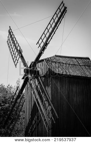 old wooden windmill in the village black and white