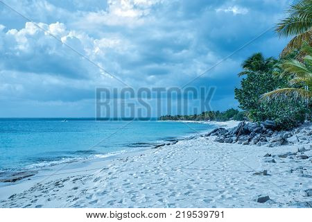 Travel photography - tropical beach with a cloudy sky (Catalina island, Dominican Republic).