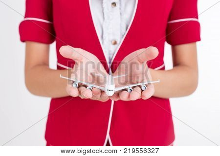 Closeup Of Air Hostess Holding Airplane Model With White Background Woman Stand And Smile At Isolate