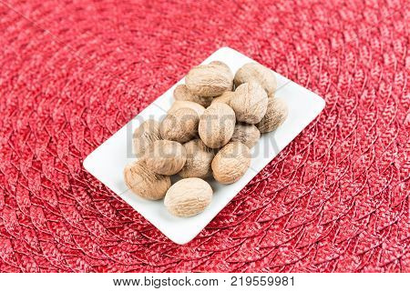 Pile Of Whole Dried Nutmeg Seed For Flavoring