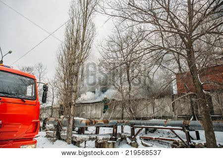 Voronezh, Russia - December 25: Fire in an industrial warehouse on Lantenskaya Street, rubber is burning, lots of smoke and flames, firefighters and MES rescue workers are struggling with a fire