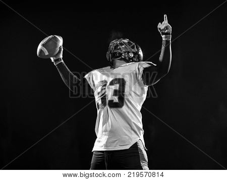 american football player celebrating after scoring a touchdown on field at night