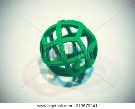 Abstract object of a green color printed by 3d printer on white background. Fused deposition modeling, FDM. Progressive modern additive technology. Concept of 4.0 industrial revolution
