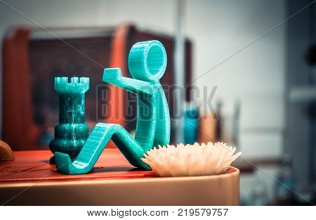 Some abstract isolated object printed on a 3d printer blurred background. Fused deposition modeling, FDM. Progressive modern additive technology. Concept of 4.0 industrial revolution
