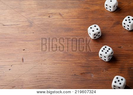 Heap of dice on rustic wooden table. Gambling devices. Game of chance concept. Copy space for text.