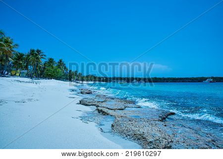Travel photography - tropical seascape with a white beach and palms (Catalina island, Dominican Republic).