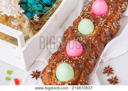 Traditional Greek Easter bread - tsoureki in Easter decorations with painted eggs and flowers. Easter Festival concept.