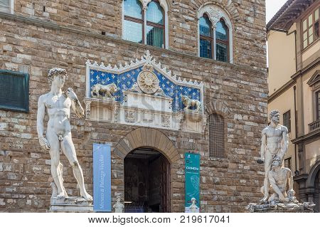 Florence Italy - April 03 2017: Entrance to Palazzo Vecchio with frontispiece and statues а replica of Michelangelo's David and Baccio Bandinelli's Hercules and Cacus.