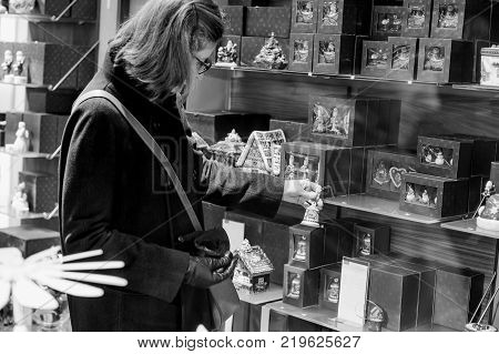 STRASBOURG FRANCE - DEC 23 2017: Woman shopping inside Villeroy & Boch ceramic porcelain gifts dishware during Christmas winter holidays - search for the perfect gift and Christmas tree