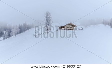 snowy and foggy montain wooden cabin landscape