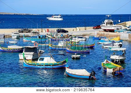 SAN PAWL, MALTA - APRIL 2, 2017 - Traditional Maltese Dghajsa fishing boats moored in the harbour with views towards the coastline San Pawl Malta Europe, April 2, 2017.