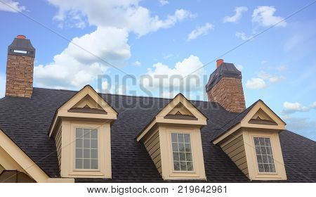 Three Dormers and Two Chimneys on Residential Roof