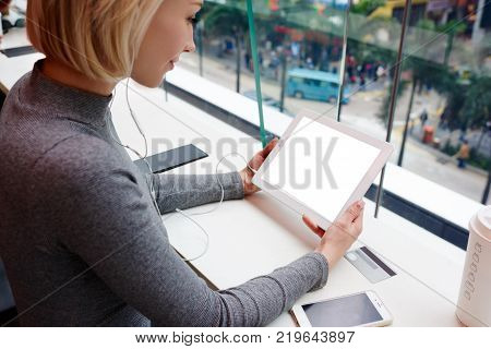 Young Female Blonde Hipster Girl With Short Haircut In Casual Wear Enjoying Leisure Sitting In Coffe
