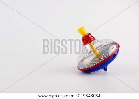 Colorful whirligig isolated on white background. Peg top made of plastic.