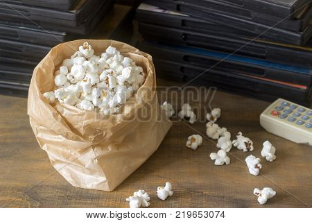 Pop corn and laser discs on a wooden surface. Rustic style, selective focus.