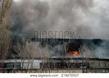 Fire in an industrial warehouse or Factory on Lantenskaya Street in Voronezh, rubber is burning, lots of smoke and flames, firefighters and MES rescue workers are struggling with a fire
