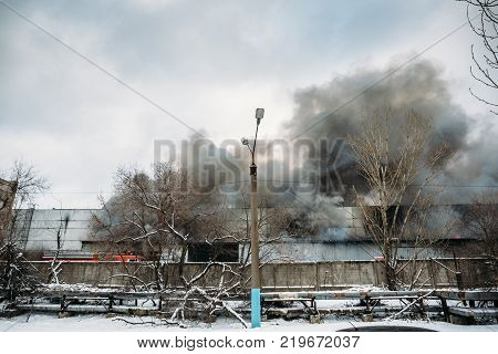 Fire in an industrial warehouse or Factory on Lantenskaya Street in Voronezh, rubber is burning, lots of smoke and flames, firefighters and MES rescue workers are struggling with a fire