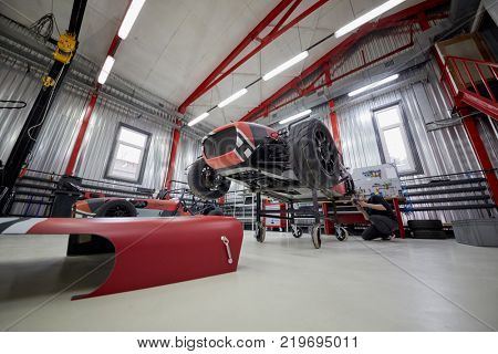 MOSCOW, RUSSIA - OCT 27, 2017: (PR) Man works with racing car on wheeled rack based on Lotus Seven in garage of DB 527 company producer of russian sports cars .