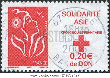 FRANCE - CIRCA 2005: A stamp printed in France Tsunami Victim Relief shows a national symbol Marianne de Lamouche and emblem of the Red Cross circa 2005