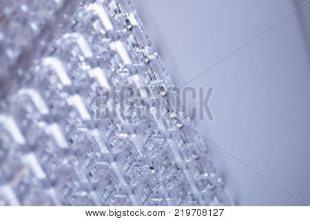 Abstract high-tech background. A sheet of transparent plastic or glass with the cut out holes. Laser cutting of plexiglass.