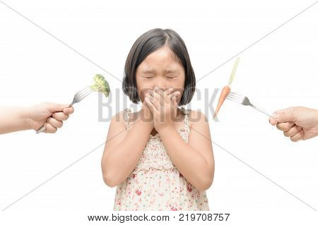 Asian Child Girl With Expression Of Disgust Against Vegetables Isolated On White Background