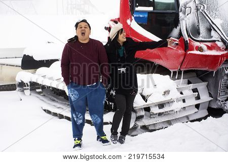 Thai People Husband And Wife Travel And Posing For Take Photo With Snowploughs Machine At Top Of Mou