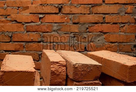 background of a brick wall and several bricks in the foreground