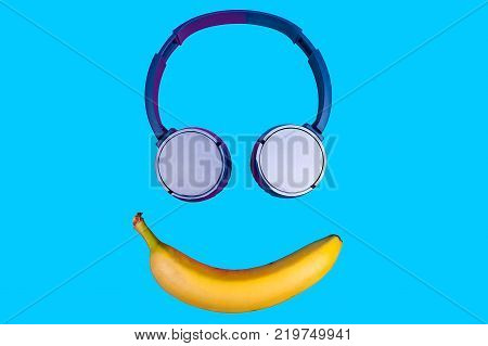 Pop art flat concept of banana and headphones on vivid colored background forming a smile face. Flat style and colors