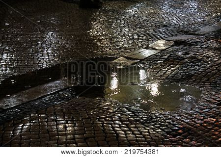 Puddle With Raindrops During Night Walk In The City Center