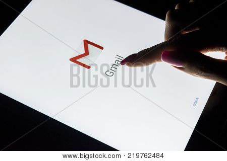 Sankt-Petersburg Russia December 21 2017: A woman's hand is touching screen on tablet computer iPad Pro at night with open Google Gmail application. Gmail is a free e-mail service provided by Google.