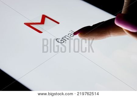 Sankt-Petersburg Russia December 21 2017: A woman's hand is touching screen on tablet computer iPad Pro at night with open Google Gmail application. Gmail is a free e-mail service provided by Google.
