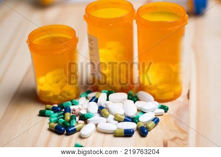 assortment of pharmacutical drugs with pill bottles in the background.