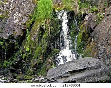 Waterfall From The Thawed Waters. Melting Snow In The Hilly Tundra. Waterfall