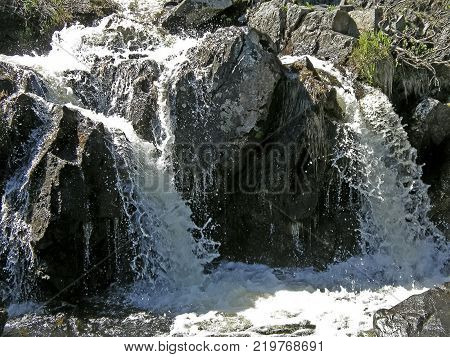 Waterfall From The Thawed Waters. Melting Snow In The Hilly Tundra. Waterfall