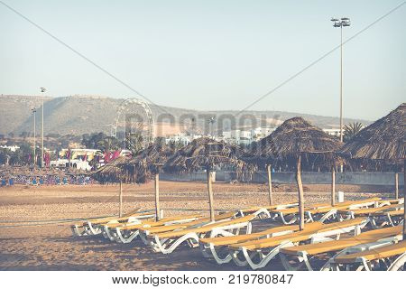 Beach Loungers And Umbrellas On The Sea. Main Beach In Agadir City Located On The Shore Of The Atlan